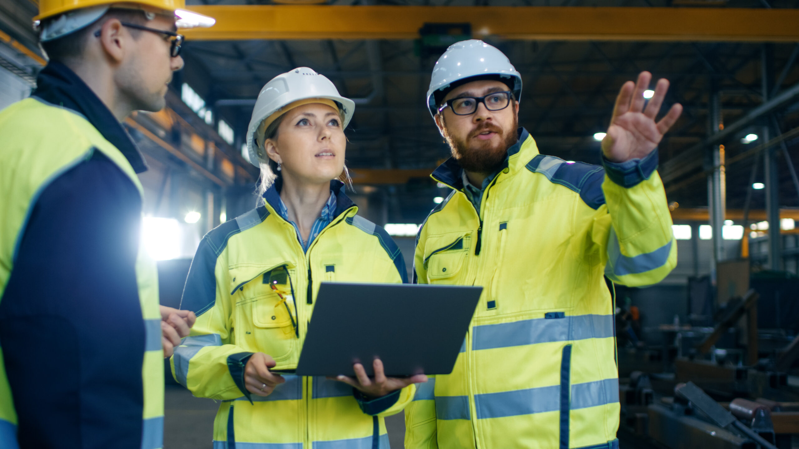 Industrial-Engineers-Talk-with-Factory-Worker-while-Using-Laptop-879813920-scaled