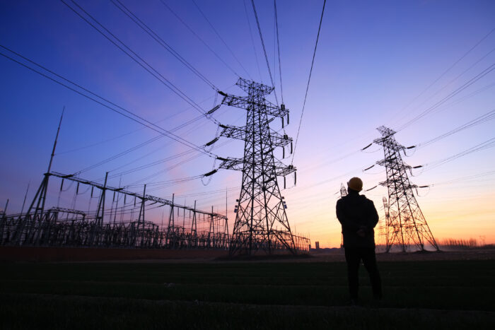 In the evening, electricity workers and pylon silhouette, Power workers at work