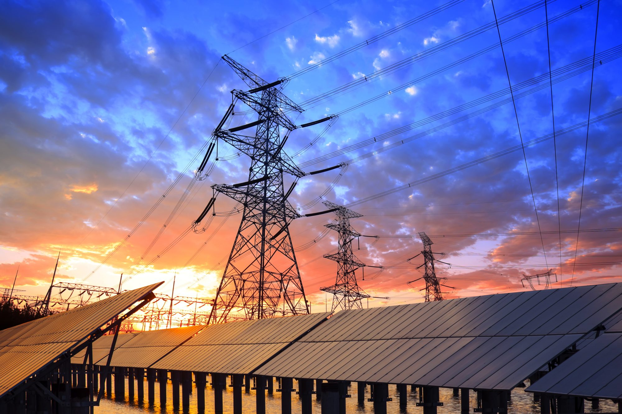 56eb414a-transition-to-renewables-from-hydrocarbons-pylon-and-photovoltaic-panels-1143865401
