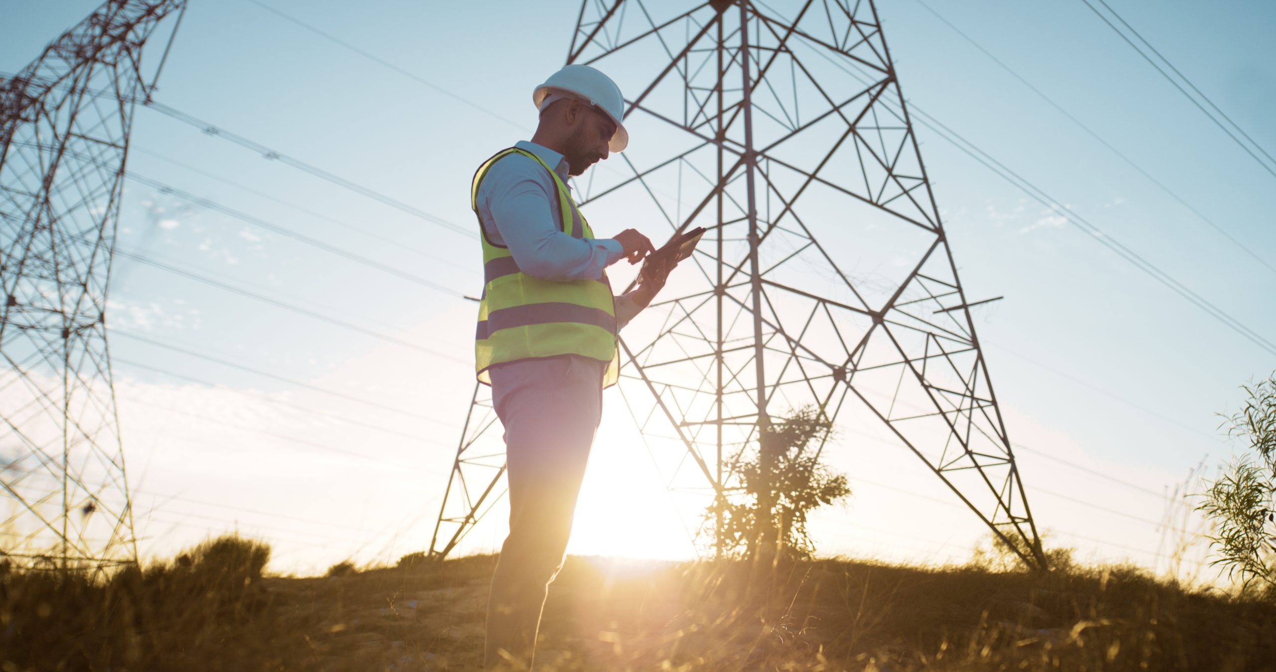 Man, tablet and electrical engineer with engineering in power station to test electricity transmission system or safety check. Inspector, sunset or tech app for energy distribution or turbine control
