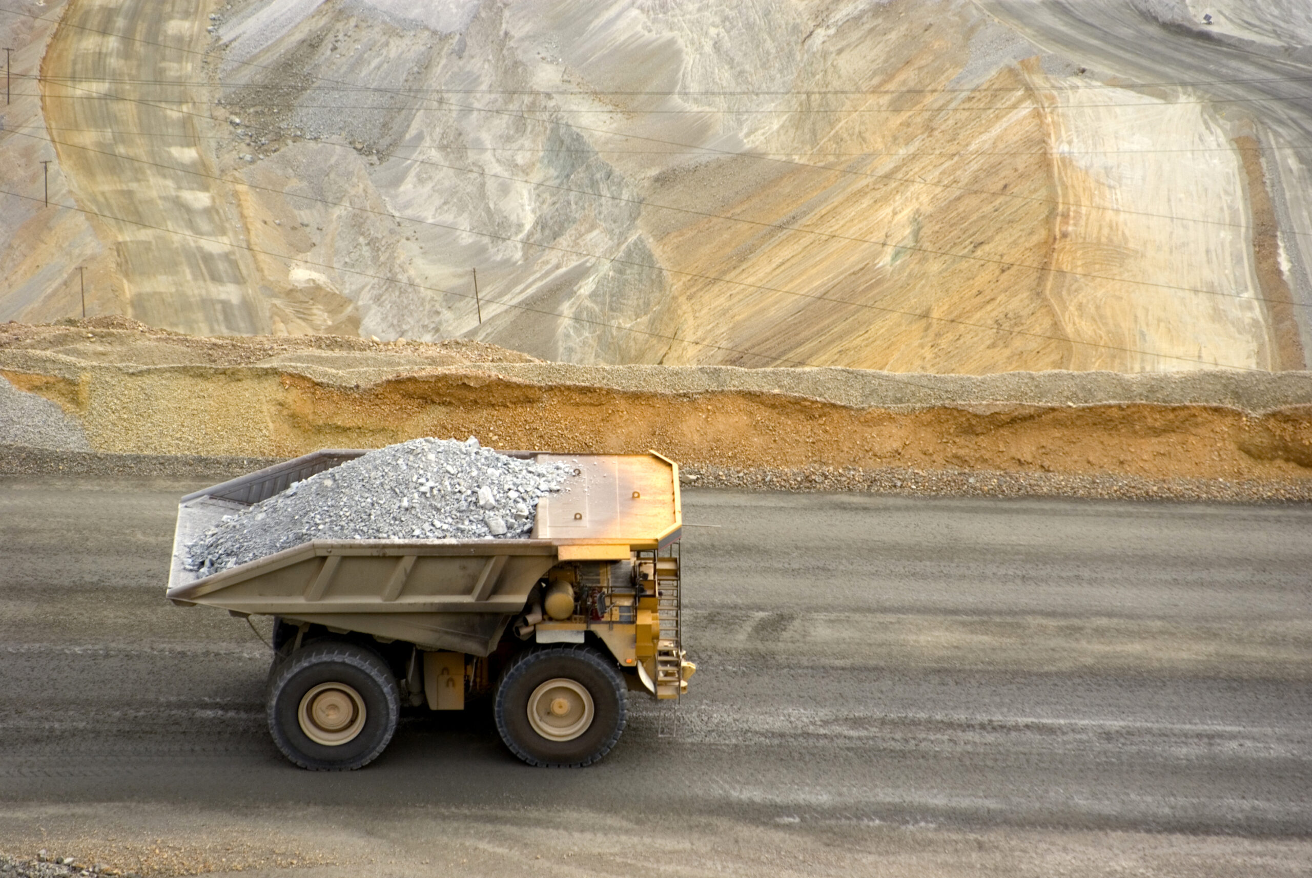 Yellow-large-dump-truck-in-Utah-copper-mine-seen-from-above-157501301-scaled-1