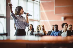fbb49cc4-business-people-listening-to-the-public-speaker-1131145949