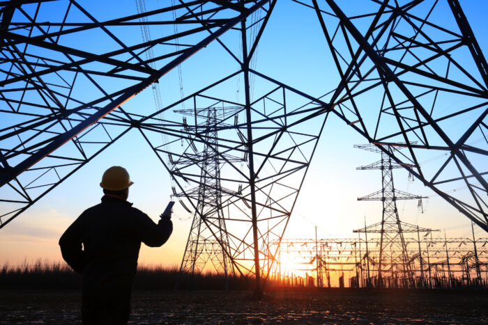 Electricity-workers-and-pylon-silhouette-1148713243