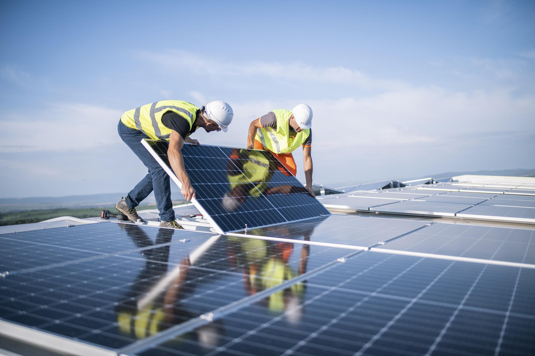 Two workers installing photovoltaic system.