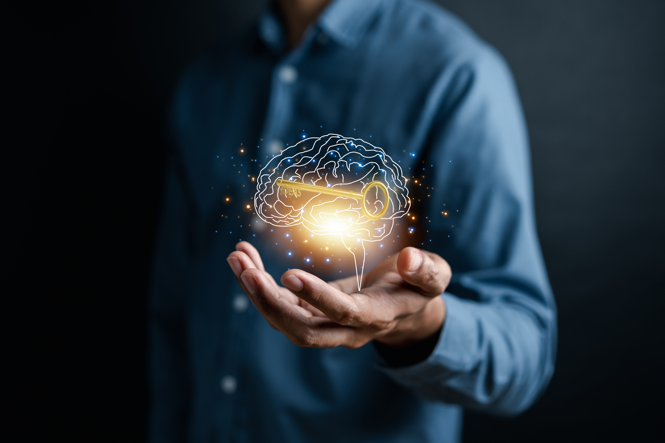 Hand holding virtual human brain and golden key icon