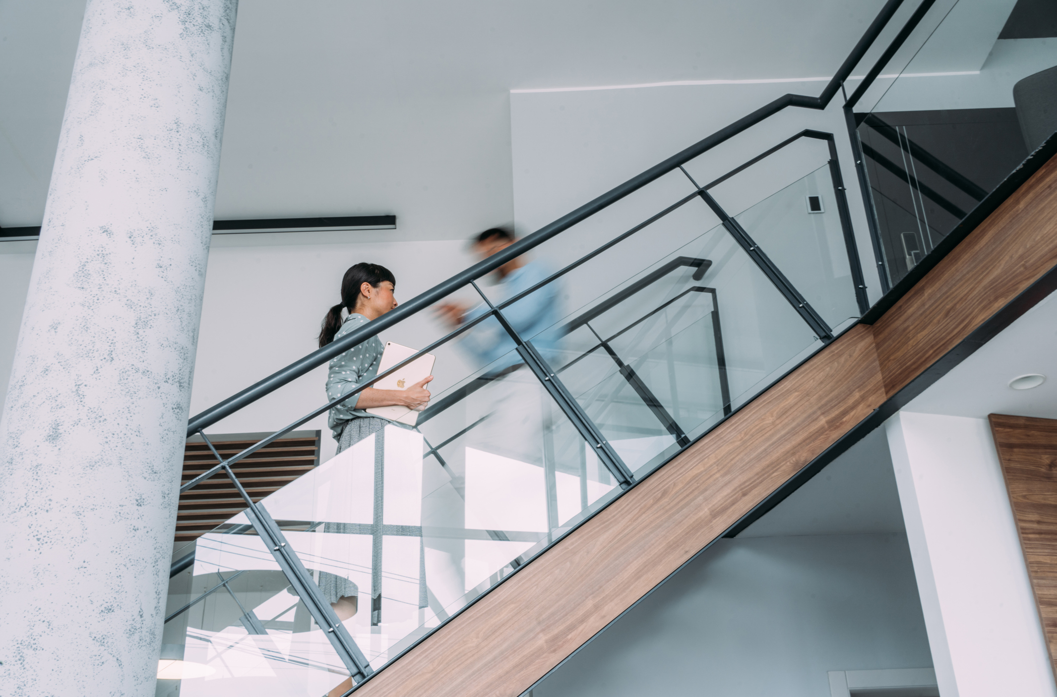 Businesspeople walking on busy office staircase.