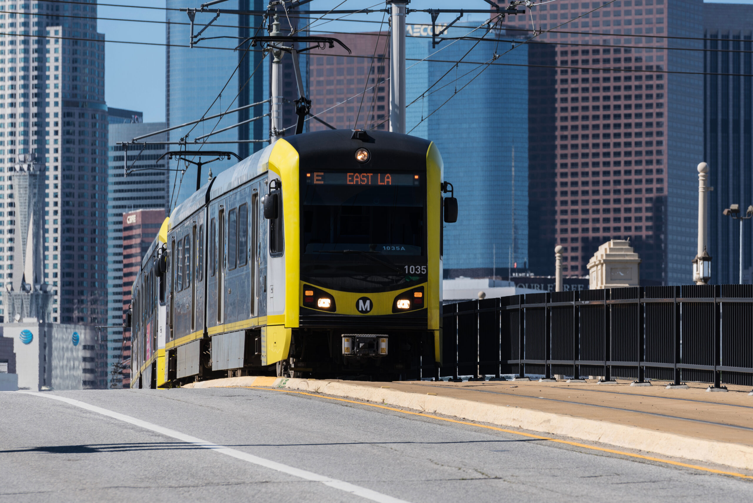 Los Angeles, California, USA - February 11, 2024: Metro E Line commuter train crossing the 1st street bridge with downtown Los Angeles skyline in background.