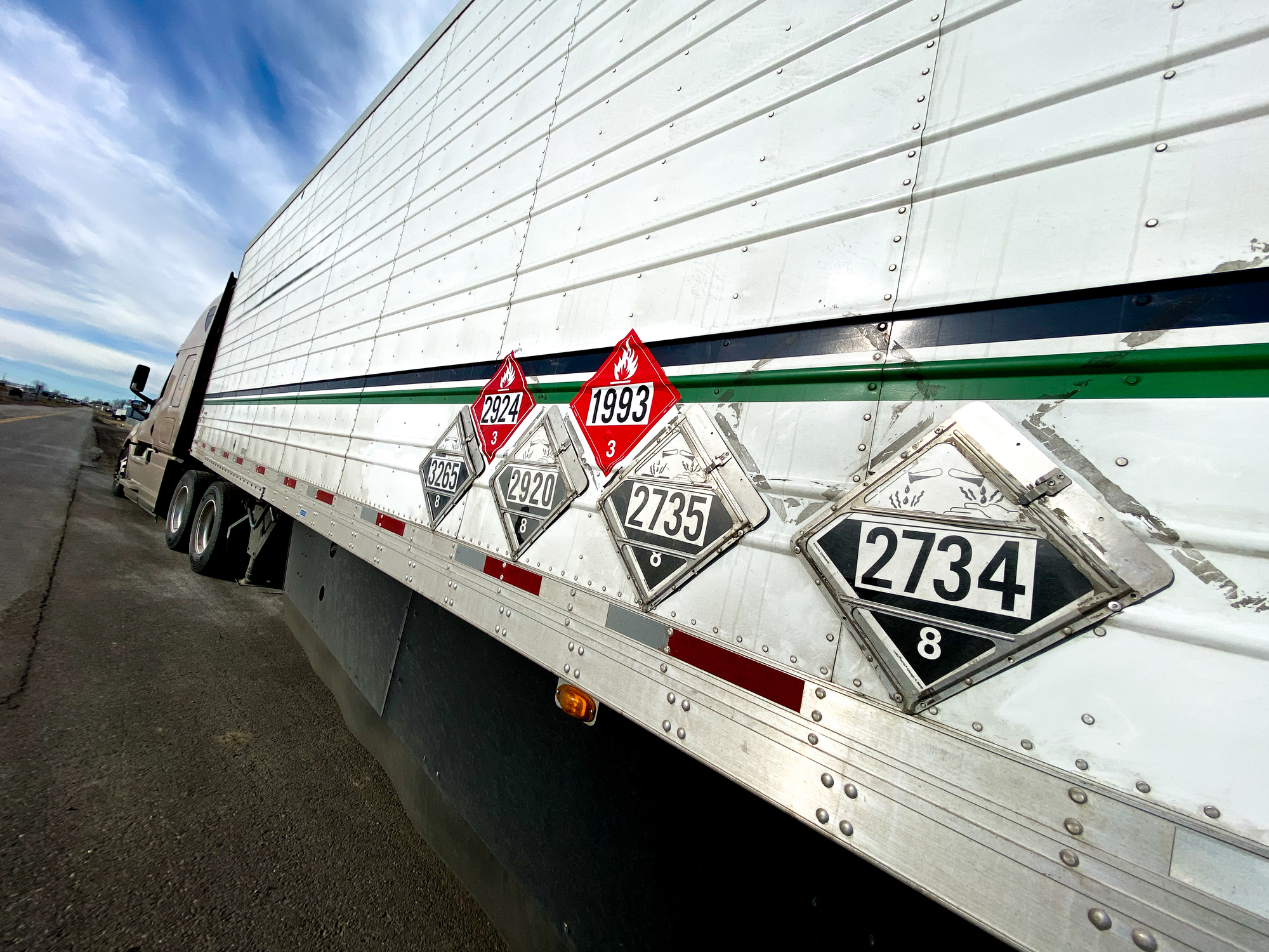 A semi truck with DOT hazard signs on the side