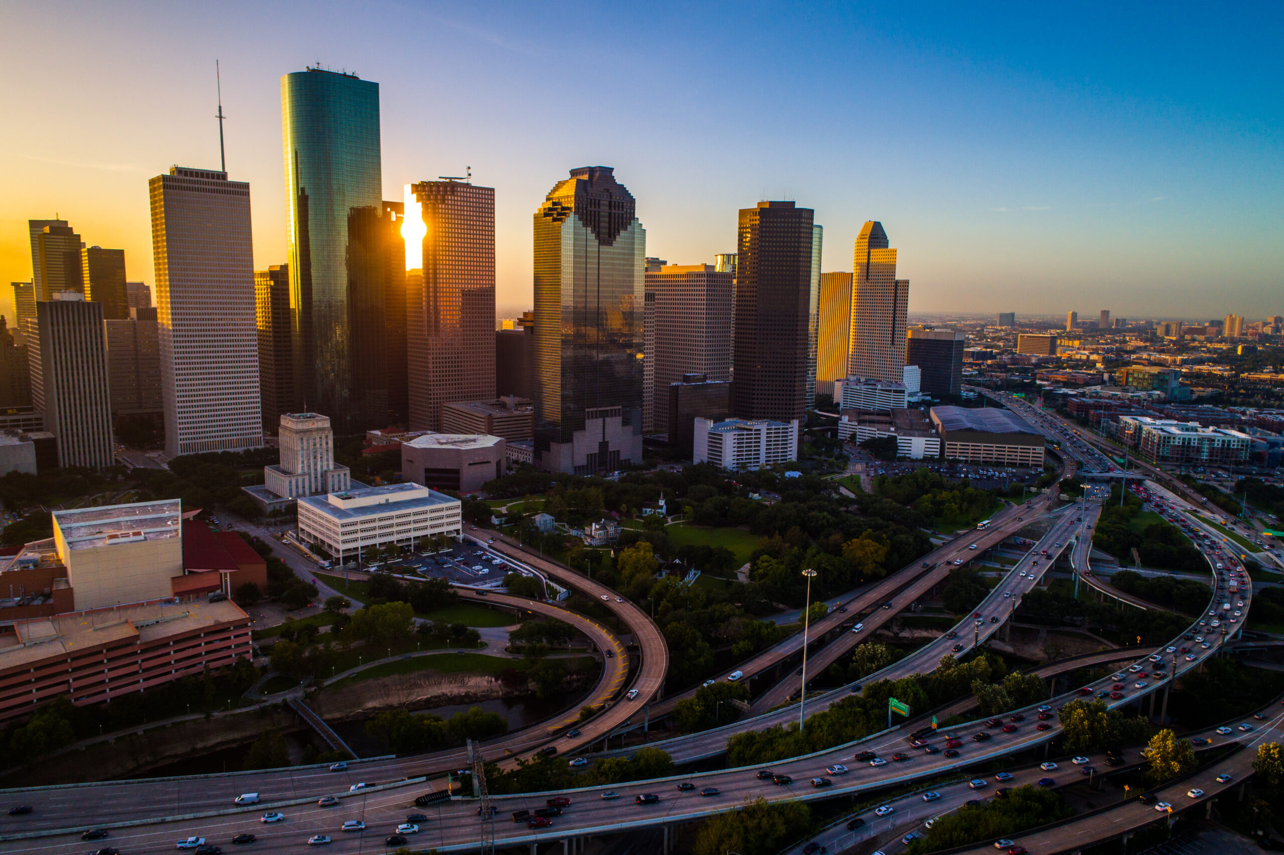 - Houston Texas aerial drone sunrise view cityscape skyline colorful morning downtown - highways , traffic , office buildings and high rises Home sales and modern architecture of the Houston real estate market - new modern homes for sale on Houston Texas on a sunny day